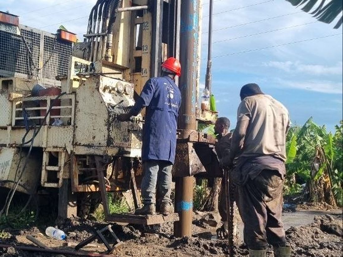 A K.E.Y. Engineering crew member in a red hard hat working at the wellhead